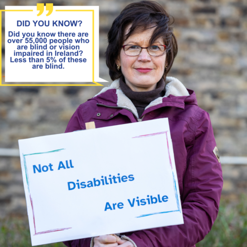 A female Vision Ireland service user who is wearing glasses is holding a sign which reads not all disabilities are visible. In the top left corner of the image a text box also reads Did you know there are over 55,000 people who are blind or vision impaired in Ireland? Less than 5% of these are blind. 