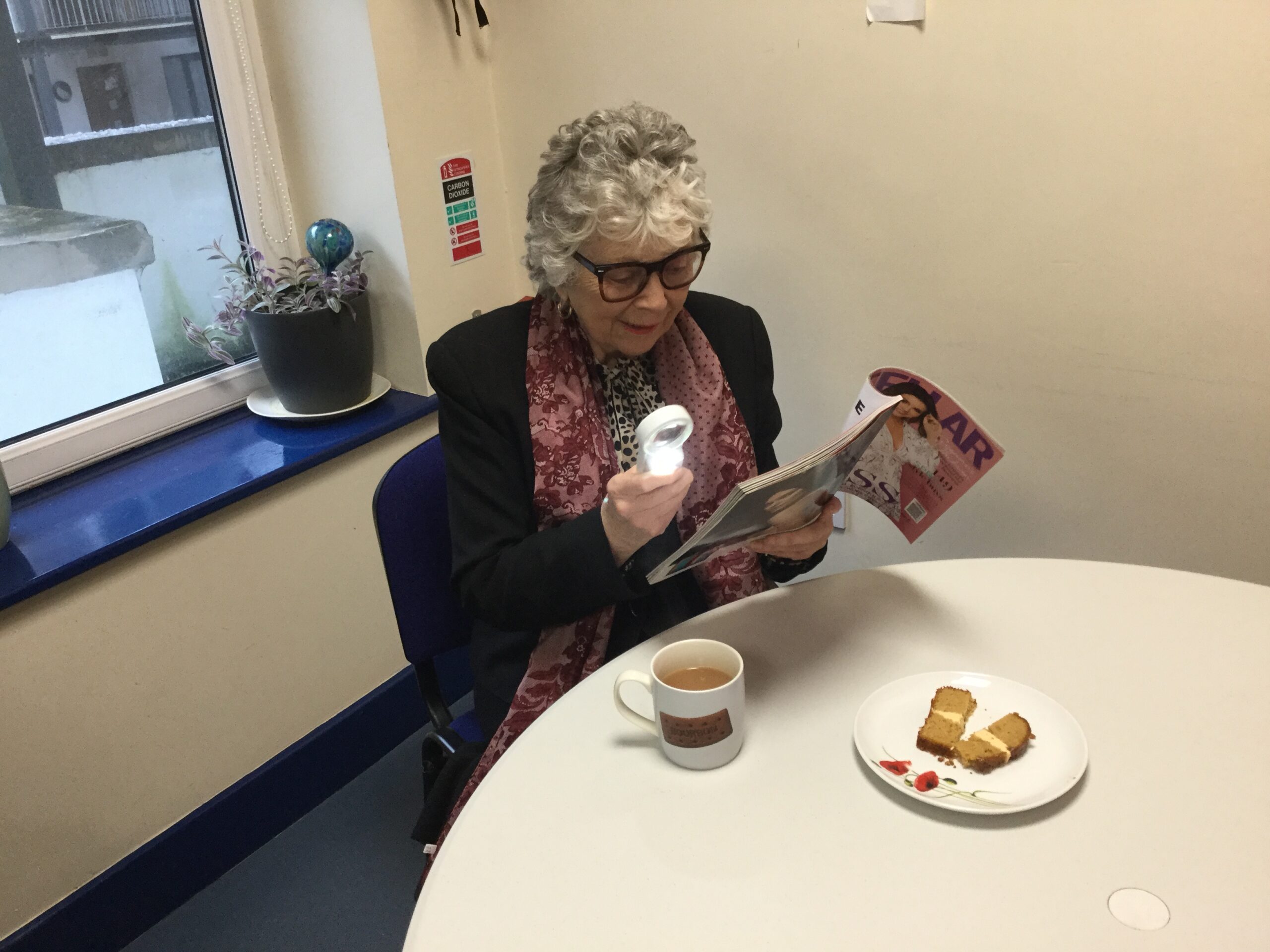 Image of Margaret reading using magnifier