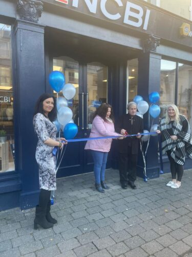 Former Lord Mayor of Fermoy, William Hughes, cuts the ribbon to open NCBI Fermoy's new location alongside Helen White, Elaine Williams, area manager of NCBI Fermoy (right) and NCBI Fermoy store manager, Laura Nolan (left).