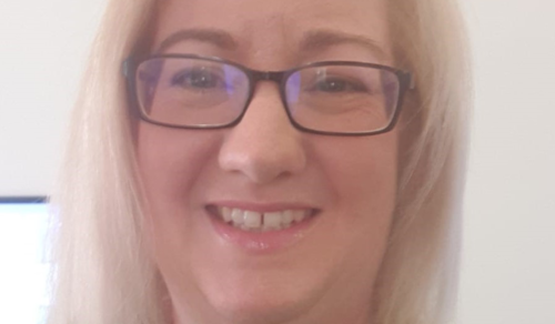 A close up image of Deirdre Leech who is smiling. Deirdre is wearing black framed glasses and has blonde hair.