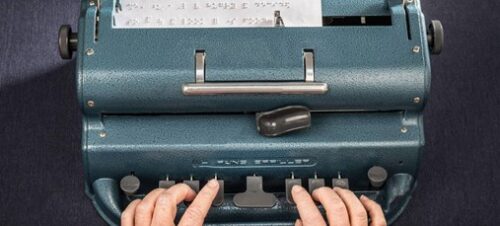 Hands typing on Perkins Brailler