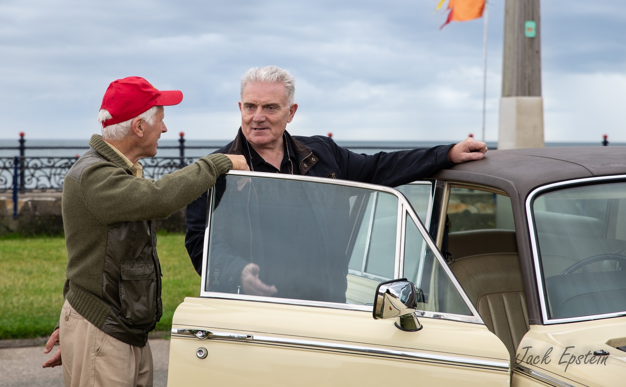 image of kevin byrne standing with a man while his hand is rested on his vintage car