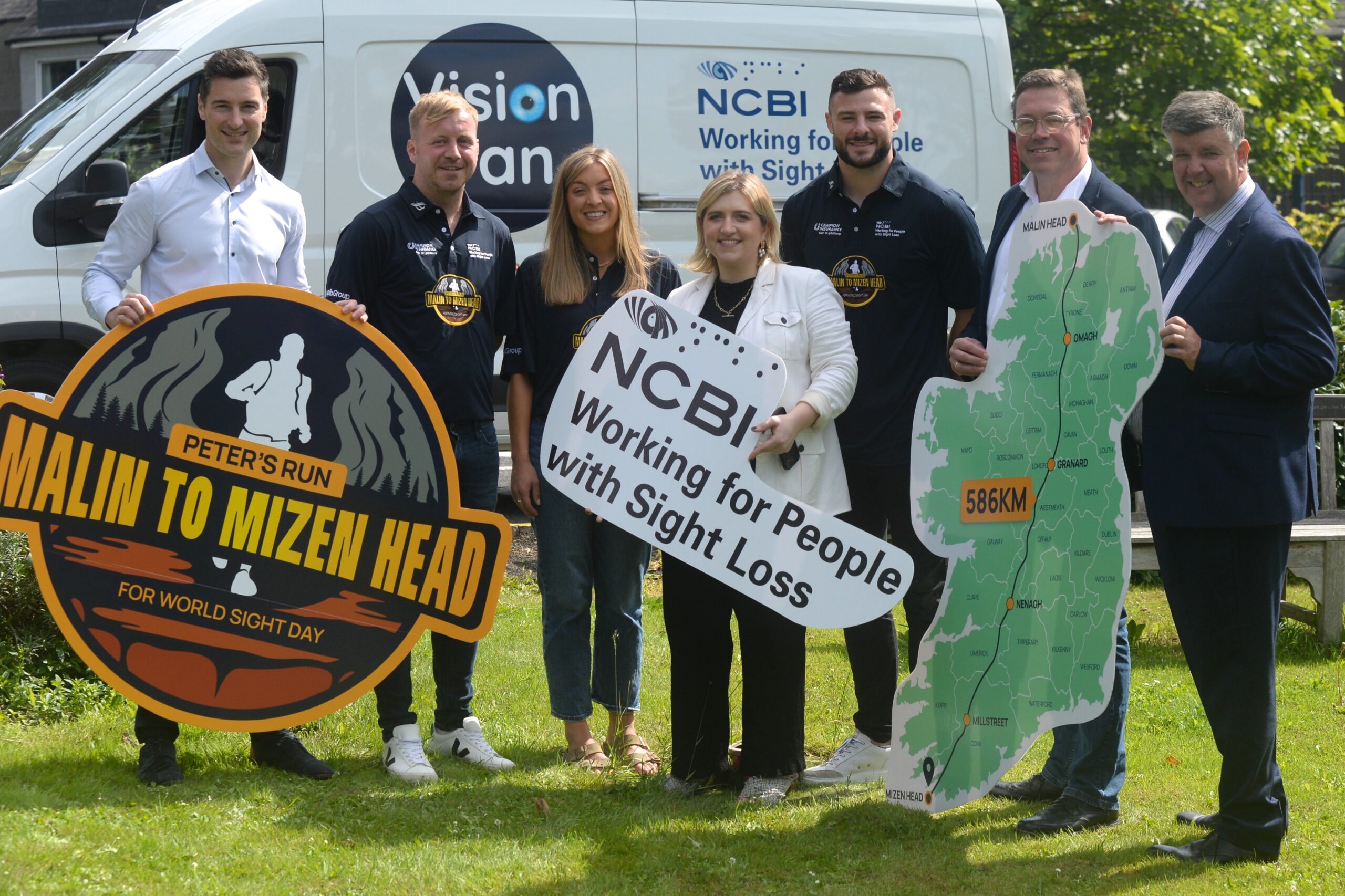 Aaron Mullaniff (NCBI), Peter Ryan, Gemma OGorman, Katie O'Dea (NCBI), Robbie Henshaw, Rob Tyrrell (Campion Insurance) and Kevin Whelan (NCBI) are all standing on a patch of grass holding signs for Peter's Run, NCBI and a large map of Ireland which shows the route of the run. They are standing in front of a white van which is branded as the Vision Van by NCBI.